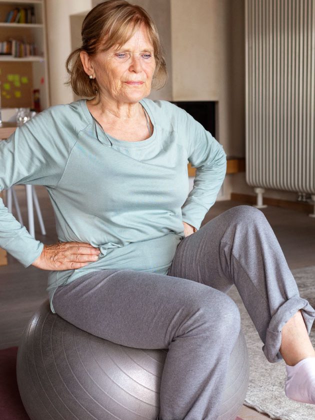 Senior performing seated marching exercise for core muscle training.